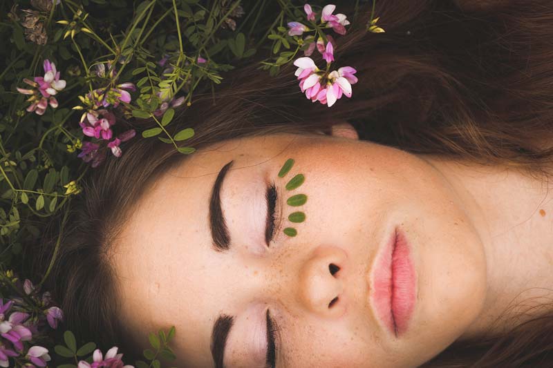 face of beautiful woman laying in grass